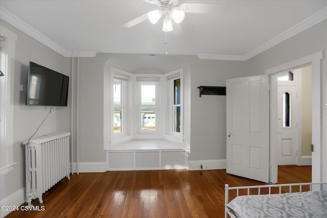 unfurnished bedroom featuring dark hardwood / wood-style flooring, radiator, ornamental molding, and ceiling fan