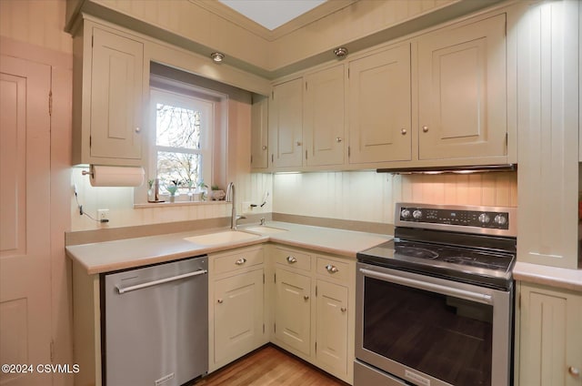 kitchen with light hardwood / wood-style floors, sink, and appliances with stainless steel finishes