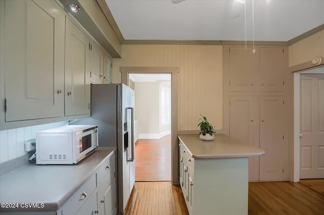 kitchen featuring kitchen peninsula, light hardwood / wood-style flooring, and crown molding