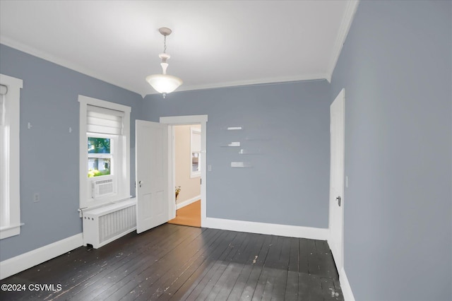 unfurnished room featuring cooling unit, crown molding, dark wood-type flooring, and radiator