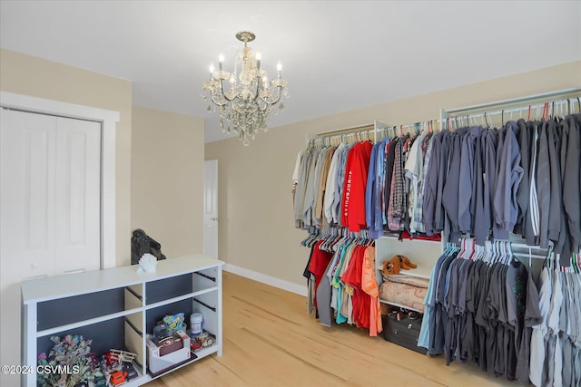 spacious closet featuring wood-type flooring and a notable chandelier