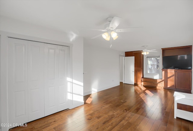 unfurnished living room with ceiling fan and dark hardwood / wood-style flooring