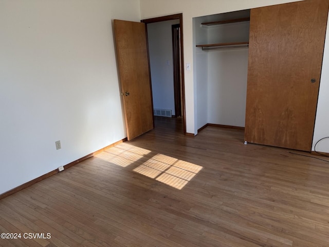 unfurnished bedroom with hardwood / wood-style flooring and a closet