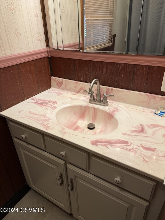 bathroom featuring tile patterned floors, wooden walls, and vanity