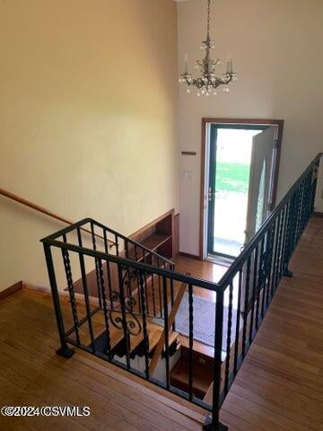 stairway featuring hardwood / wood-style flooring and a chandelier