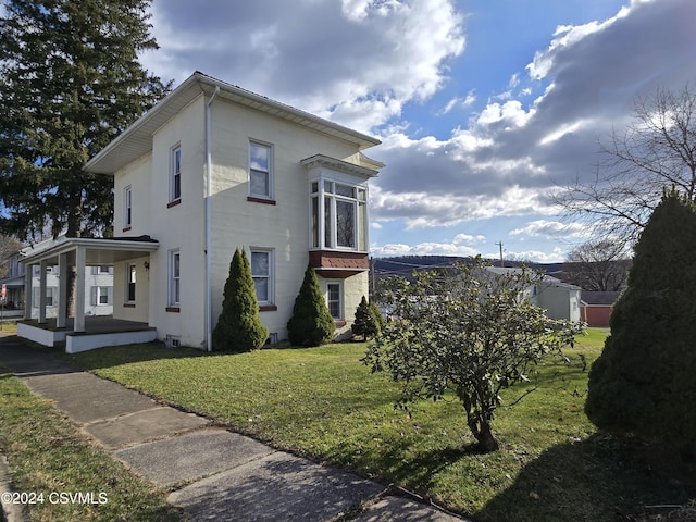 view of home's exterior featuring a lawn and a porch