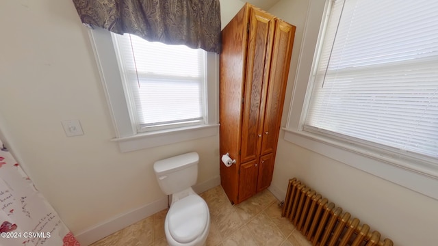 bathroom with radiator heating unit and toilet