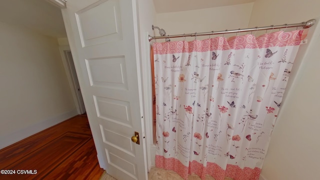 bathroom with hardwood / wood-style flooring and walk in shower