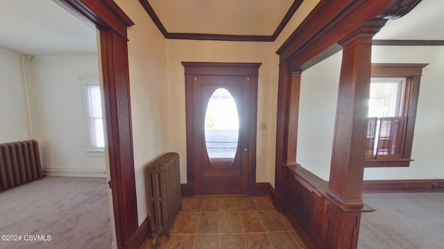 foyer featuring radiator heating unit, ornate columns, and a wealth of natural light