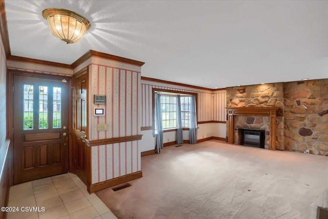 entryway featuring a fireplace, light colored carpet, and ornamental molding