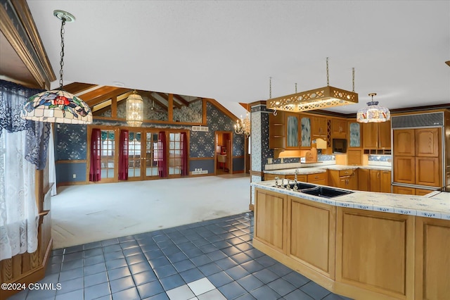 kitchen featuring black appliances, dark tile patterned floors, decorative light fixtures, and vaulted ceiling