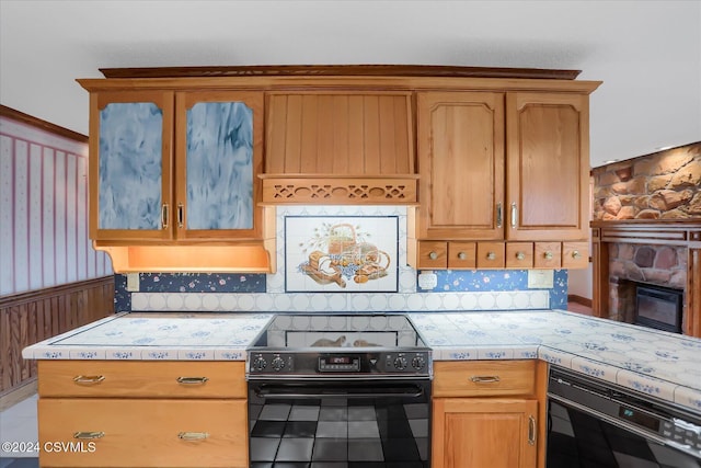 kitchen with black electric range, backsplash, and a fireplace