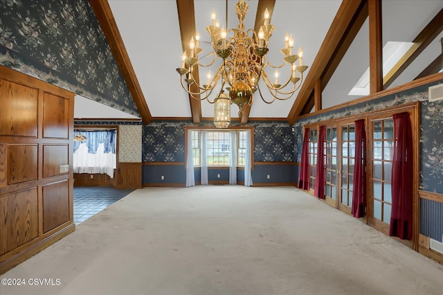 interior space with carpet flooring, high vaulted ceiling, a wealth of natural light, and a chandelier