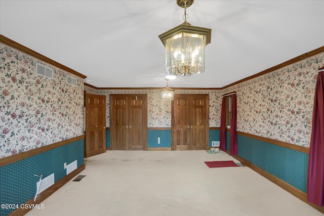 carpeted empty room featuring ornamental molding and an inviting chandelier