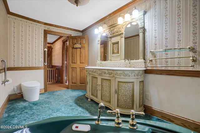 bathroom featuring toilet, vanity, and ornamental molding