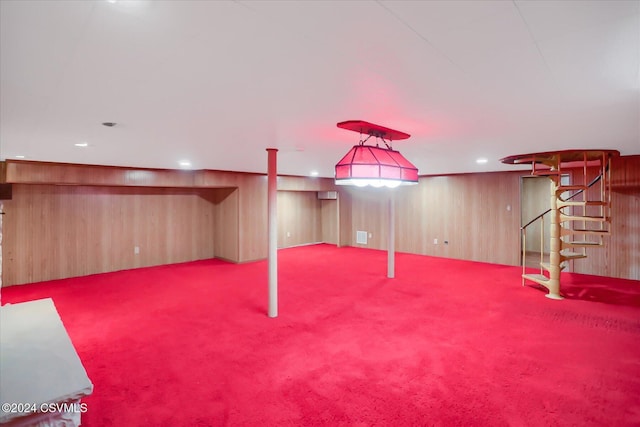 basement featuring light colored carpet and wood walls