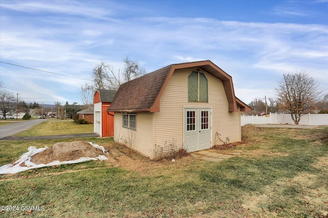 view of side of property with a yard and an outbuilding