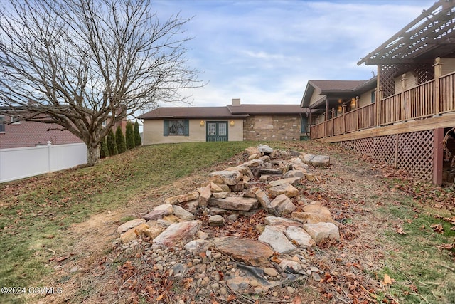 rear view of property featuring a pergola and a wooden deck