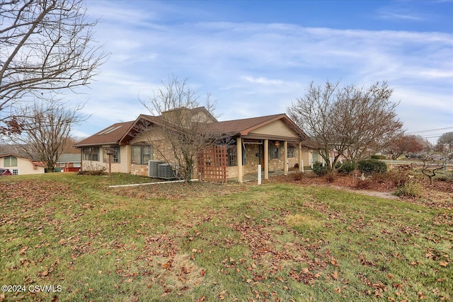 view of front of home featuring cooling unit and a front yard