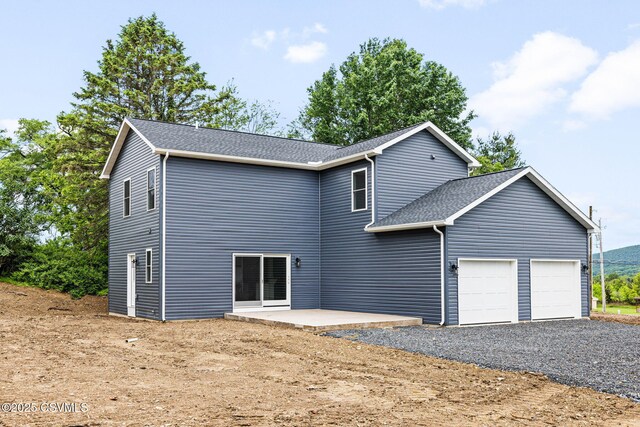 151 Hillside Ave, Elysburg, PA 17824 - back of house with an attached garage, roof with shingles, a patio, and driveway