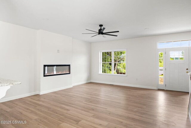 151 Hillside Ave, Elysburg, PA 17824 - unfurnished living room with healthy amount of natural light, light wood-style flooring, and a glass covered fireplace