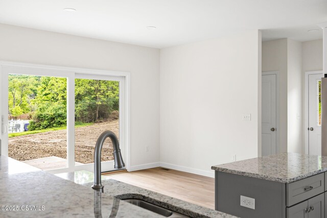 151 Hillside Ave, Elysburg, PA 17824 - kitchen featuring light wood-type flooring, light stone countertops, gray cabinets, baseboards, and a sink