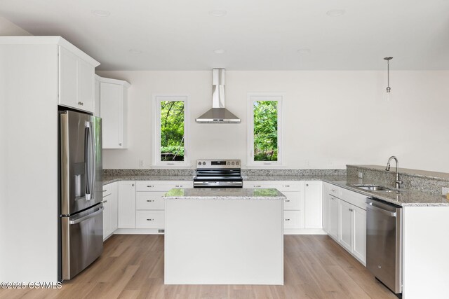 151 Hillside Ave, Elysburg, PA 17824 - kitchen with appliances with stainless steel finishes, wall chimney exhaust hood, a sink, light wood-style flooring, and light stone counters