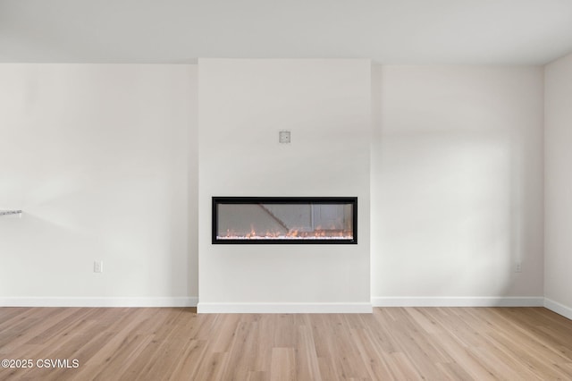 151 Hillside Ave, Elysburg, PA 17824 - unfurnished living room featuring wood finished floors, a glass covered fireplace, and baseboards