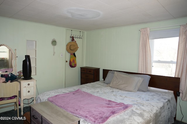 bedroom featuring wood walls