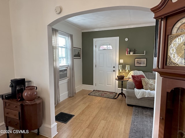 foyer entrance with cooling unit, crown molding, and light hardwood / wood-style flooring