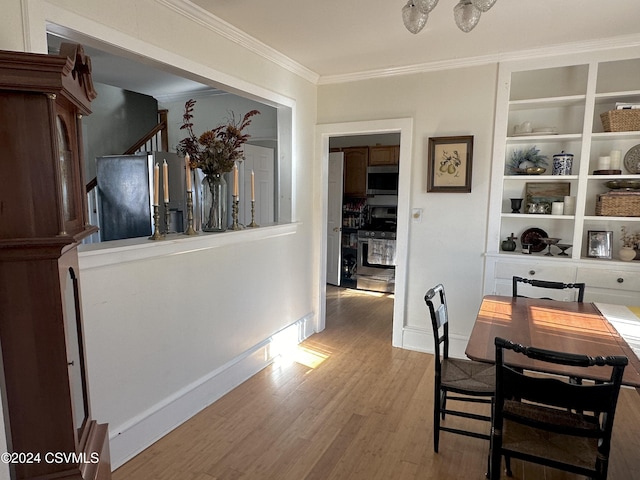 dining room with hardwood / wood-style flooring and crown molding