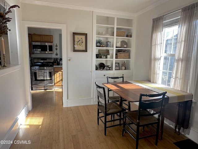 dining room featuring ornamental molding and light hardwood / wood-style flooring