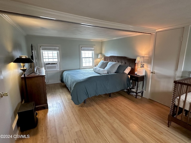 bedroom with crown molding, light hardwood / wood-style flooring, and cooling unit