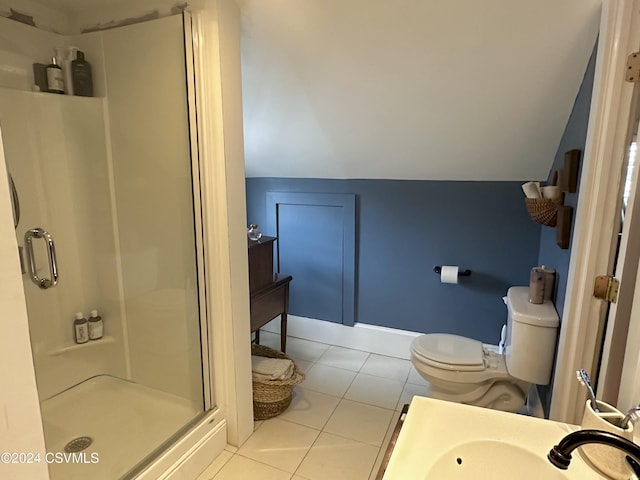 bathroom featuring lofted ceiling, tile patterned floors, sink, toilet, and an enclosed shower