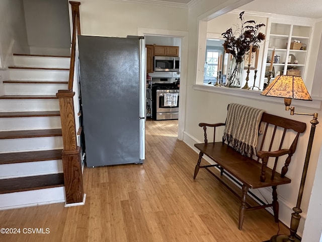 stairs with crown molding and hardwood / wood-style flooring