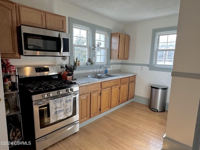 kitchen featuring plenty of natural light, light hardwood / wood-style floors, sink, and appliances with stainless steel finishes