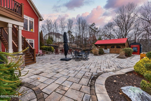 view of patio / terrace featuring stairway, outdoor dining area, a balcony, and an outdoor structure