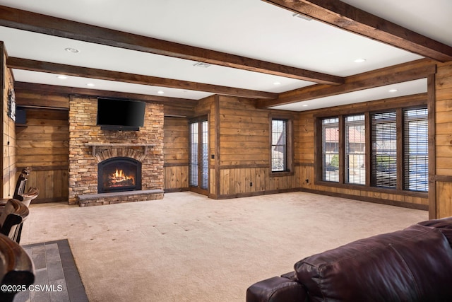 carpeted living room featuring wooden walls, beamed ceiling, recessed lighting, and a fireplace