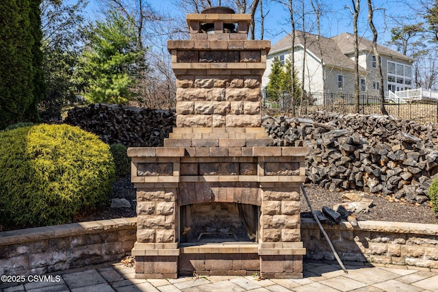 exterior space with fence and an outdoor stone fireplace