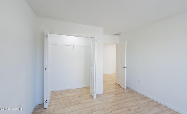 unfurnished bedroom with light hardwood / wood-style floors and a closet