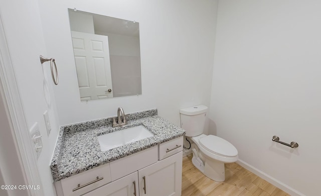 bathroom featuring hardwood / wood-style floors, vanity, and toilet