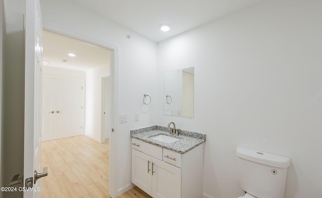 bathroom featuring vanity, wood-type flooring, and toilet