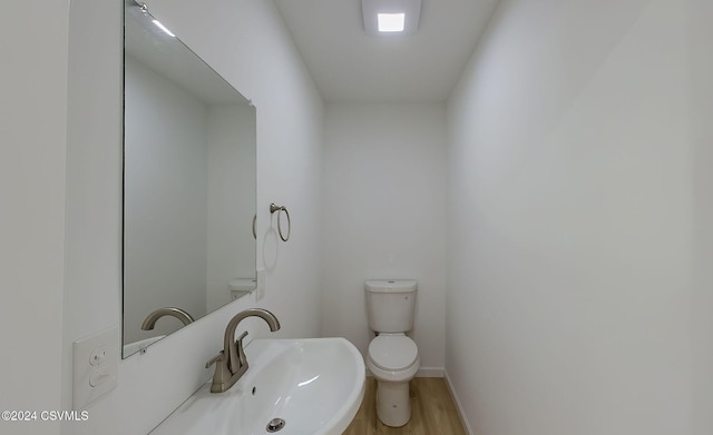 bathroom featuring toilet, wood-type flooring, and sink