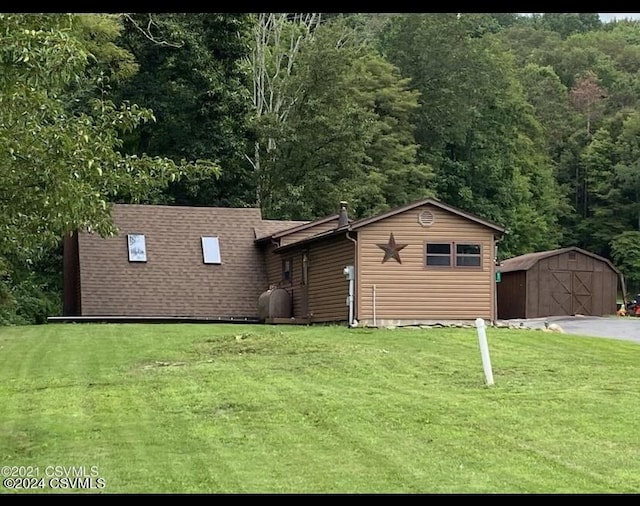 view of front of home with a shed and a front yard