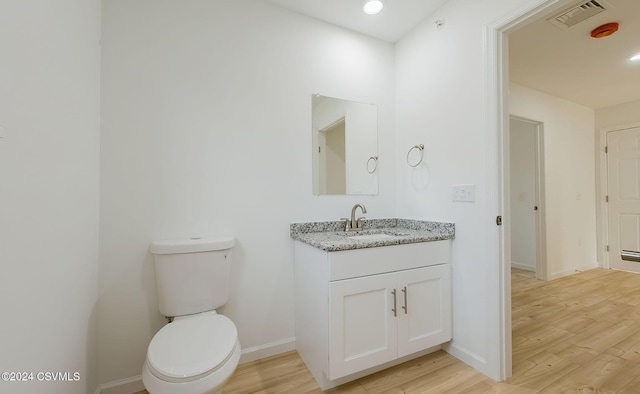 bathroom featuring hardwood / wood-style flooring, vanity, and toilet