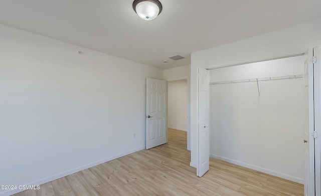 unfurnished bedroom featuring light wood-type flooring and a closet