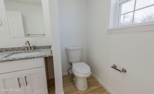 bathroom featuring wood-type flooring, vanity, and toilet