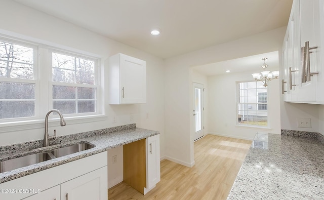 kitchen with light hardwood / wood-style flooring, white cabinets, and plenty of natural light