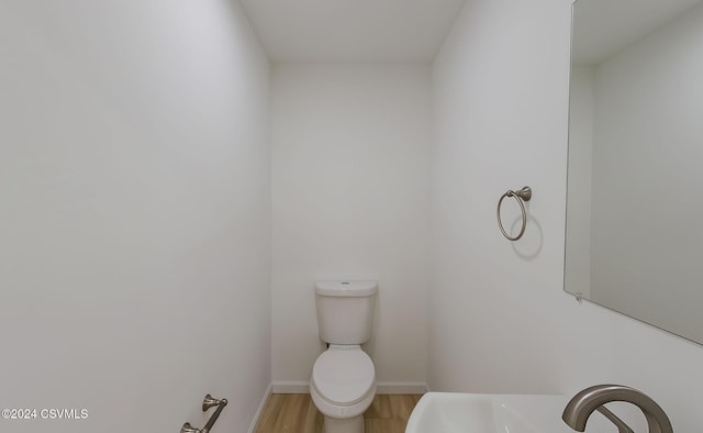 bathroom featuring toilet, wood-type flooring, and sink