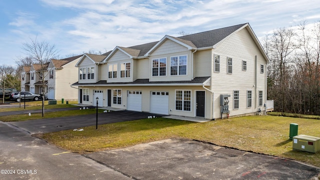 townhome / multi-family property featuring a garage and a front lawn